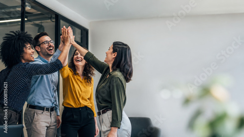 Diverse office team high five celebrating success