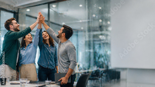 Happy business team high five in office