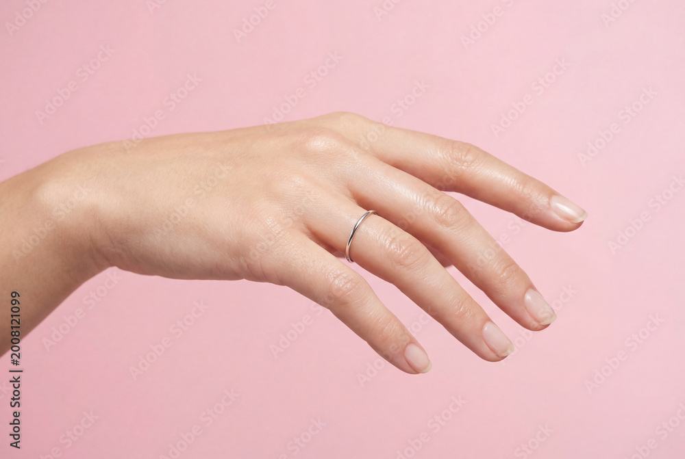 Naklejka premium Female hand with ring indicating pause on pink background