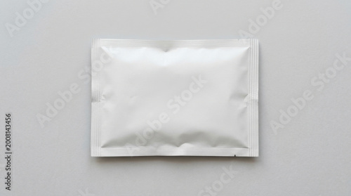 A white rectangular package lies on a gray surface indoors.