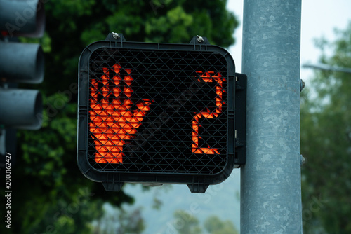 Red hand symbol and countdown timer on pedestrian crossing signal