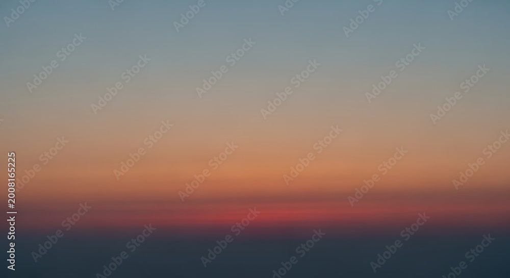 Obraz premium Serene twilight sky with soft hazy horizon transitioning from deep blue to warm orange tones