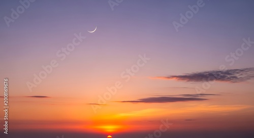 Sunset sky glows with a crescent moon over the horizon line.