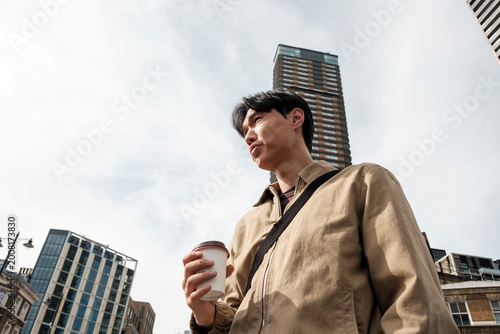 Photography Young man holding coffee cup in urban street