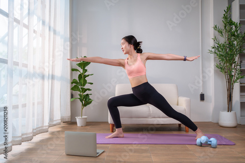 Young woman practicing yoga at home for fitness