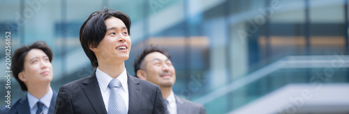 Foto 笑顔で歩くスーツで新卒採用や新人の若手ビジネスチームのポジティブ(前向き)な未来を見つめる(見上げる)リクルートイメージ　転職や就活、採用などの笑顔複数の横並び