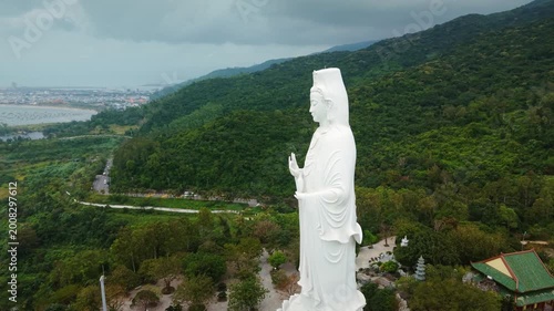 Cultural icon Lady Buddha at Linh Ung Pagoda in Da Nang Vietnam stands against hill and sea, attracting visitors worldwide. Lady Buddha statue shows Vietnamese Buddhist culture, scenic travel appeal