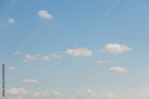 Wispy white clouds scattered across a vast pale blue sky on a bright day