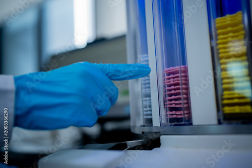 Laboratory worker uses equipment to sort samples in a clean room during study in a science facility