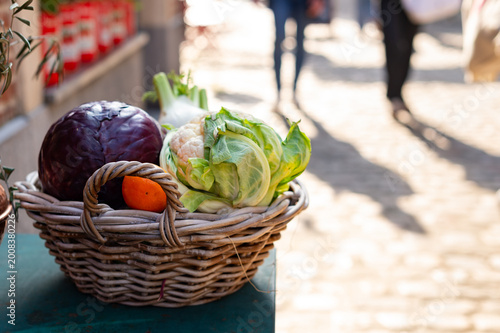 Canvas Print Close up of a wicker basket filled with fresh vegetables including red cabbage and cauliflower on a street market in Paris, France