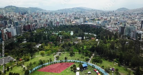 Aerial drone movement from Quito city skyline to La Carolina Park with green space and activity area