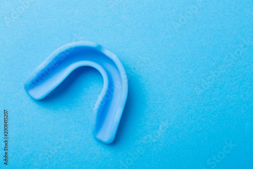 Sports dental protection mouthpiece for boxing and mma on a vibrant colored paper background.