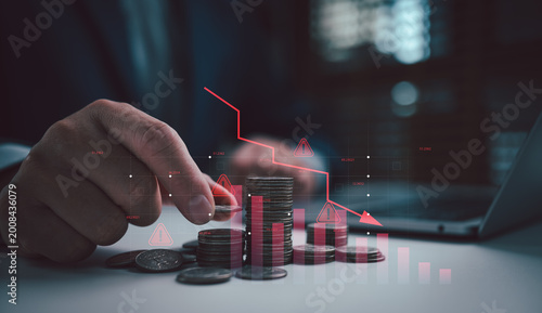 Canvastavla Hand arranging coin stacks beside a falling red chart on desk, symbolizing financial crisis, investment warning, stock market decline, low returns, capital loss, and business risk concept