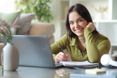 Photos Happy student e-learning at home looking at you