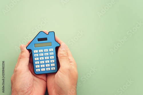 Calculator in the shape of a house. Idea of expenses and real estate