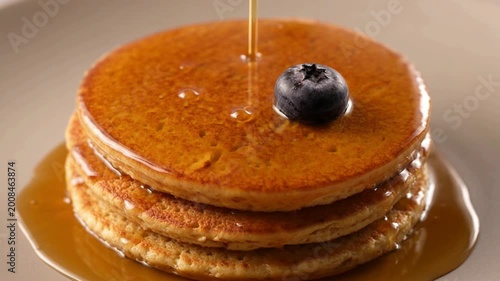 Syrup drizzled on stacked pancakes.
