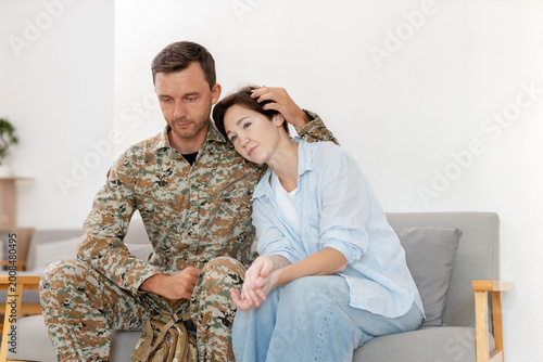 Obraz na plátne Military soldier comforting sad women wife, emotional reunion, support and care concept, family love, stress, trauma recovery, relationship bonding, mental health awareness