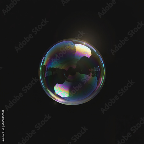 Colorful soap bubble floating against a black background  