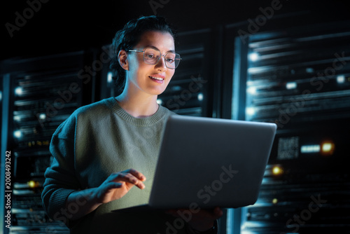 Confident IT Specialist Working on Laptop in Modern Server Room