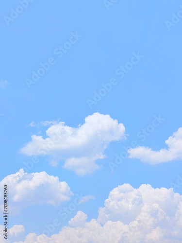 Beautiful blue sky background with white clouds on a sunny day, bright nature wallpaper, clear weather and fluffy cumulus clouds for copy space and outdoor summer background.