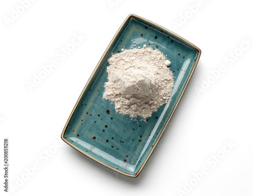 A small pile of fine white powder on a rectangular blue ceramic plate with dark speckles