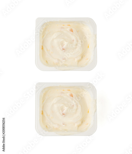 Yogurt cup isolated, yoghurt with orange fruits pieces in plastic pot, milk pudding container