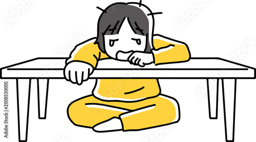 机に伏して泣く女性