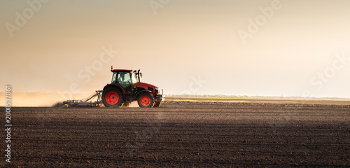 Farmer in tractor preparing land for sowing