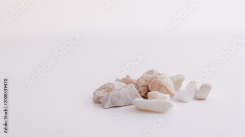 Photography Pile of small, rough, natural stones and pebbles on a clean white background