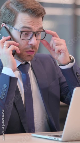 Businessman with Laptop Talking on Phone