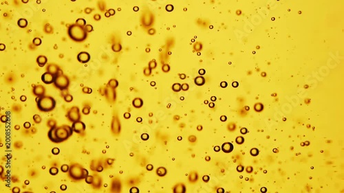 Macro shot of sunflower oil bubbles on golden background, abstract liquid texture, cooking ingredient detail, fluid pattern design.