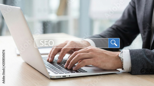 SEO concept with businessman typing on laptop and virtual search bar, symbolizing search engine optimization strategy