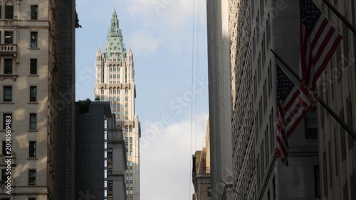 New York City Woolworth building 1913, skyscraper on Broadway in Downtown Financial District, Lower Manhattan, United States of America. Gothic historic architecture, cooper roof, USA american flag.