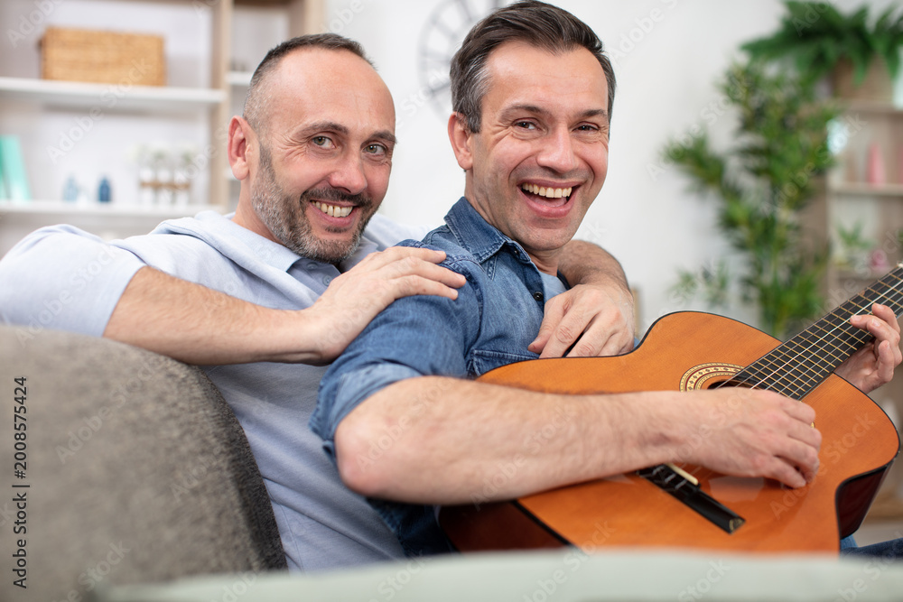 Fototapeta premium loving gay couple resting on bed at home