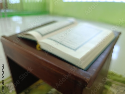 Open Holy Quran on a wooden desk inside a peaceful mosque room