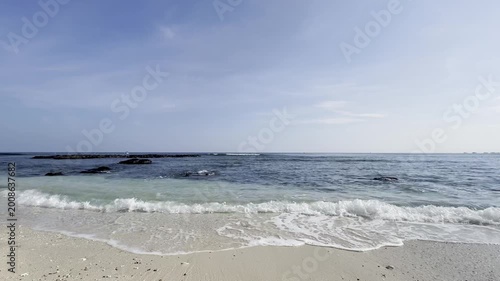 Serene Tropical Beach with Gentle Turquoise Waves Crashing on White Sand