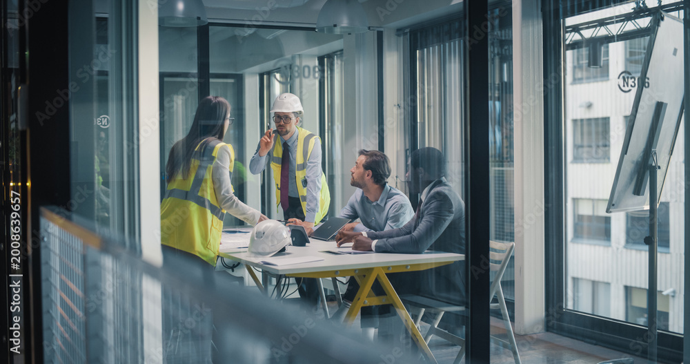 Fototapeta premium Construction and Business Leaders Meet in a Glass Office to Plan Site Work, Review Drawings, Coordinate Schedule and Budget, Discuss Safety Procedures, and Align Project Milestones