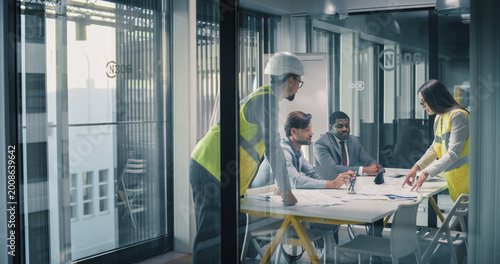 фотографія Executives and Engineers Meet in a Glass Conference Room to Review Construction