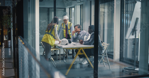 Bild auf Leinwand Project Managers and Engineers Meet in a Glass Office to Review Construction Dra