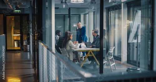 Fotografía Business Team Holds a Focused Strategy Meeting in a Glass Office, as a Female Le