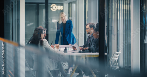 Tablou pe pânză Business Team Holds a Strategy Meeting in a Glass Conference Room as a Female Ma