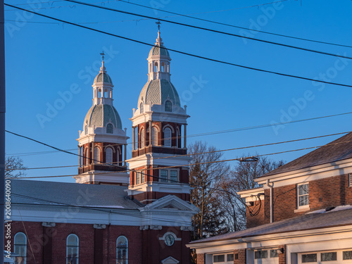 Fotografie Twin domed church towers in Ypsilanti above brick buildings