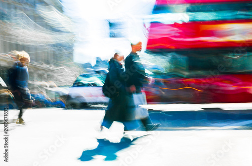 Artistic motion of people with shopping bags crossing Oxford Circus junction at sunny day. London