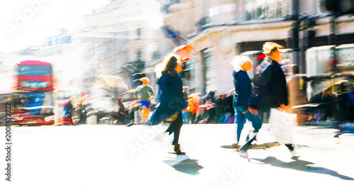 Artistic motion of people with shopping bags crossing Oxford Circus junction at sunny day. London