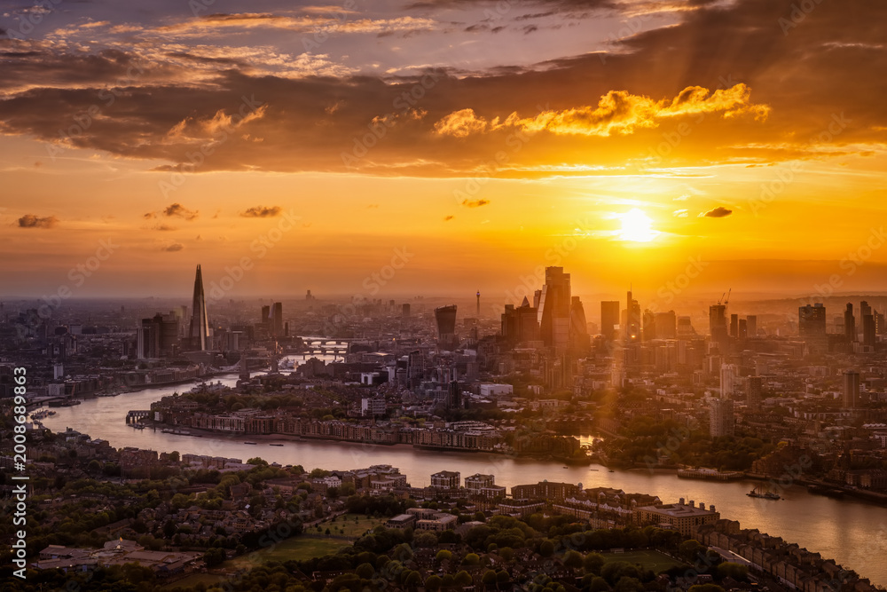 Obraz premium Beautiful summer sunset behind the urban skyline of London, England, with sunlight and cloudscape above the City