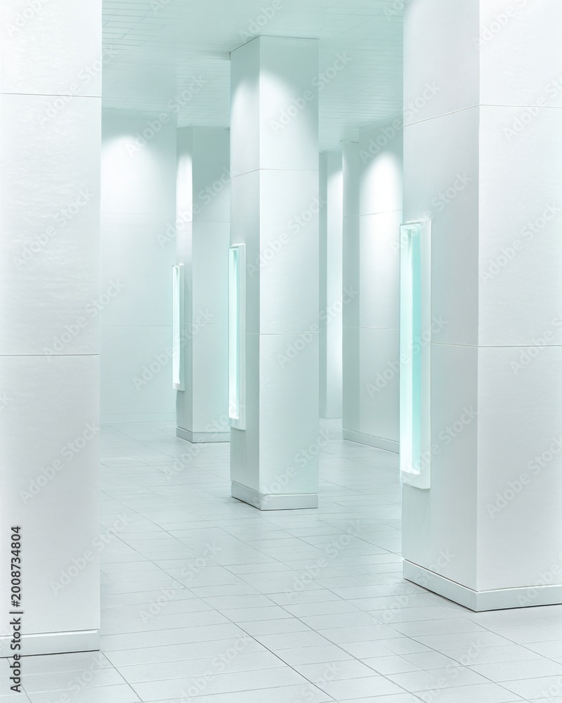Naklejka premium Serene White Hallway with Recessed Lighting and Modern Columns Creating an Ample, Airy Architectural Space