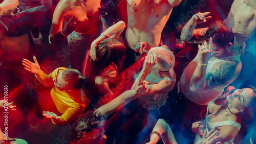 Canvas Print Aerial view of people dancing energetically in a colorful, dimly-lit club scene
