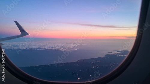 View from airplane window at sunset over the ocean and land