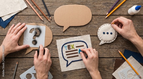 Hands crafting speech bubbles with question marks and text, a creative DIY project concept