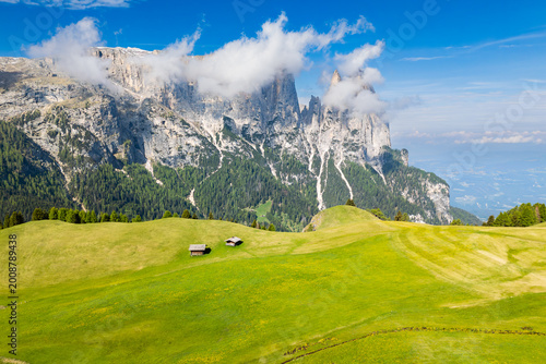Картината върху платно Dolomites mountain landscape with dramatic rock cliffs and low clouds above green alpine meadows, Alpe di Siusi, South Tyrol, Italy